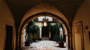 暗いアーチから見える石畳の向こうにアーチ型の入り口