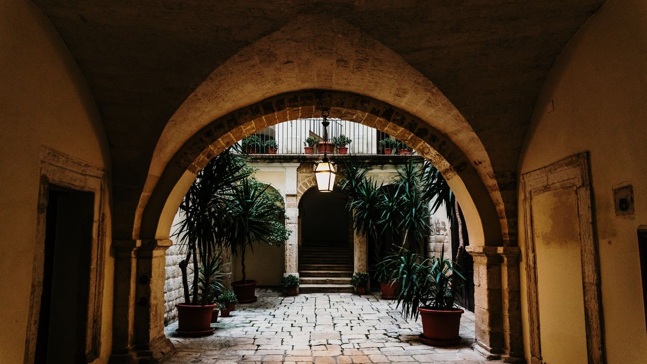 暗いアーチから見える石畳の向こうにアーチ型の入り口