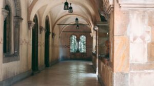 石造りの廊下。アーチ型天井の向こうの窓から見える緑